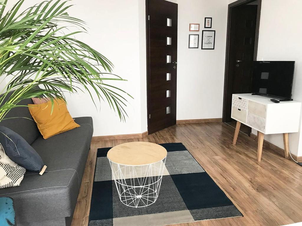uma sala de estar com um sofá e uma mesa em Apartament Zaciszny em Gdansk
