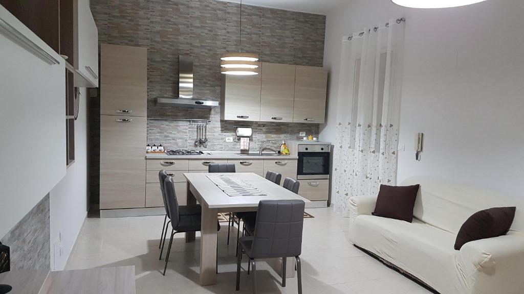 Solarino的住宿－A casa di Pamy，厨房以及带桌子和沙发的客厅。