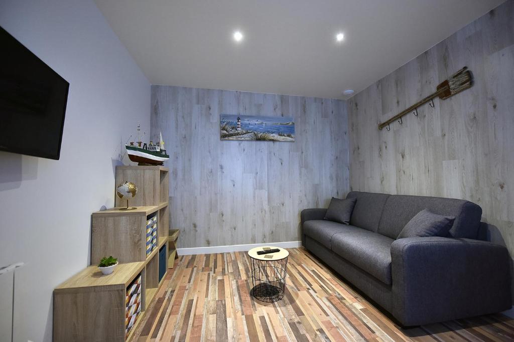 uma sala de estar com um sofá e uma televisão em Studio "Le Duffit" - RDC em Berck