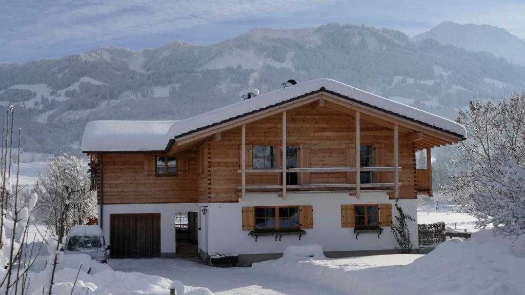 a log house with snow on the roof at Ferienwohnung Mathias Kennerknecht in Fischen