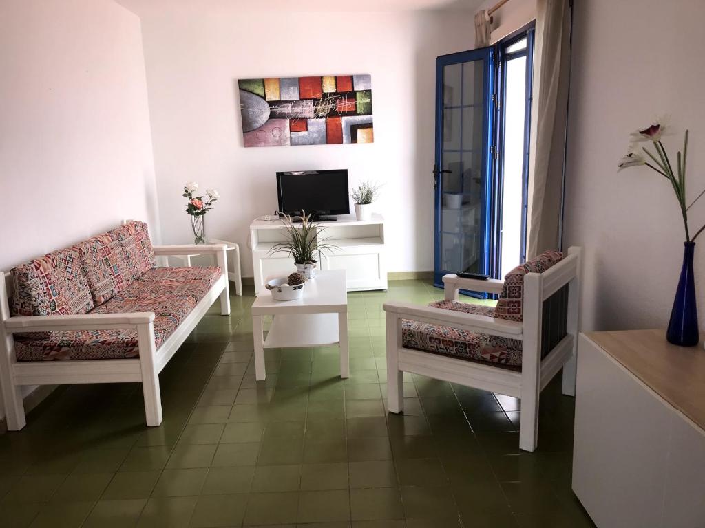 ein Wohnzimmer mit 2 Stühlen und einem TV in der Unterkunft Vivienda Vacacional Delia Castillo in Caleta de Fuste