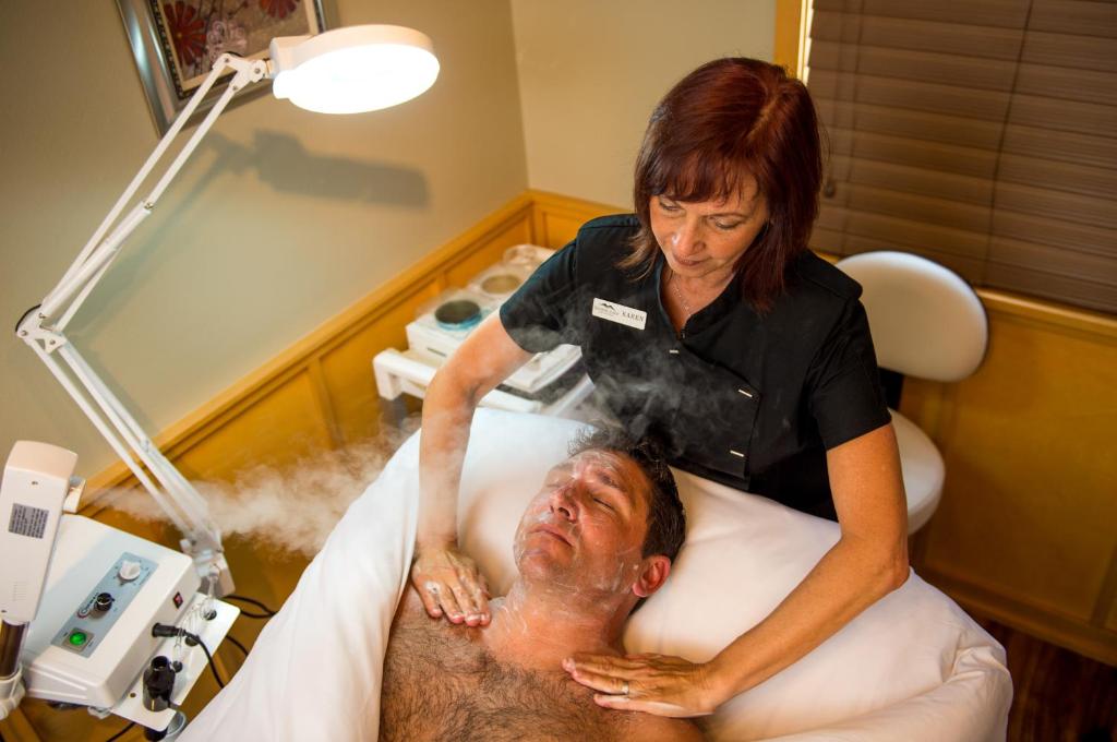 a woman is washing a man in a hospital bed at Sleeping Lady Mountain Resort in Leavenworth