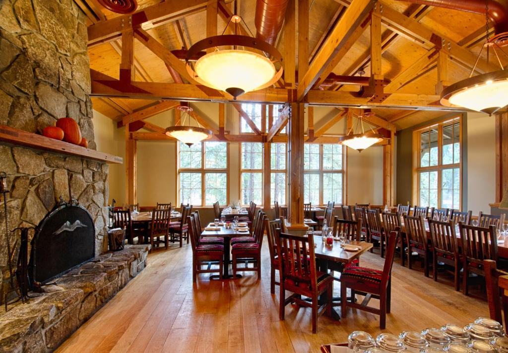 a dining room with tables and chairs and a stone wall at Sleeping Lady Mountain Resort in Leavenworth