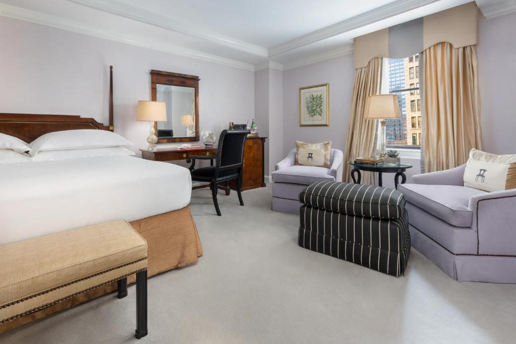 ニューヨークにあるミケランジェロ ホテルのベッド、デスク、椅子が備わるホテルルームです。