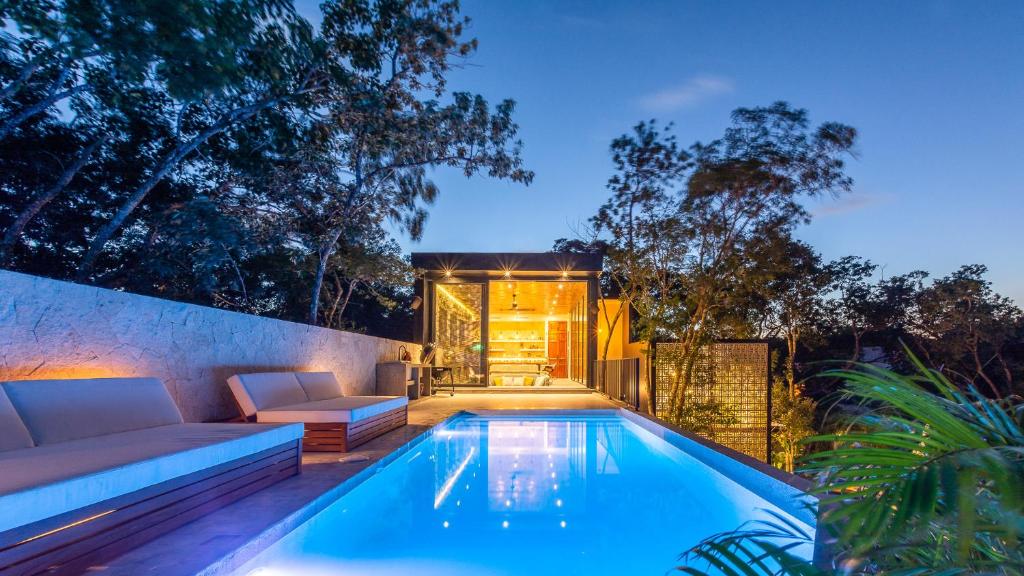 a swimming pool in a backyard with a couch at Villa LaGú Masterpiece Tulum Jungle 5BR Pool & Spa in Tulum