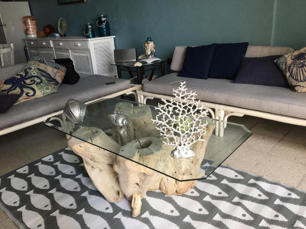 d'un salon avec une table basse en verre et une cascade d'arbres. dans l'établissement Aca life, à Acapulco