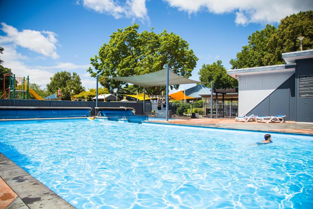 a person swimming in a large swimming pool at Hastings TOP 10 Holiday Park in Hastings