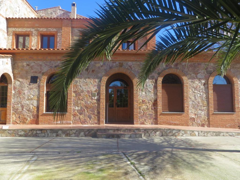 una casa con una palmera delante de ella en Hostal Rest. Campoabierto, en Valencia de las Torres