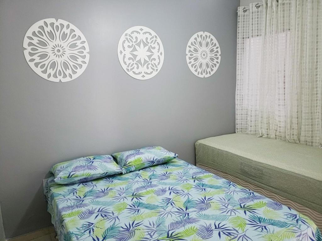 a bedroom with a bed and three plates on the wall at Apartamento Cabo Frio in Cabo Frio