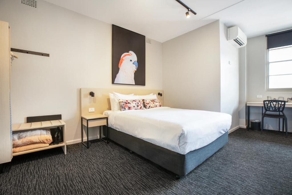 a bedroom with a bed and a painting on the wall at Nightcap at the Charles Hotel in Wollongong