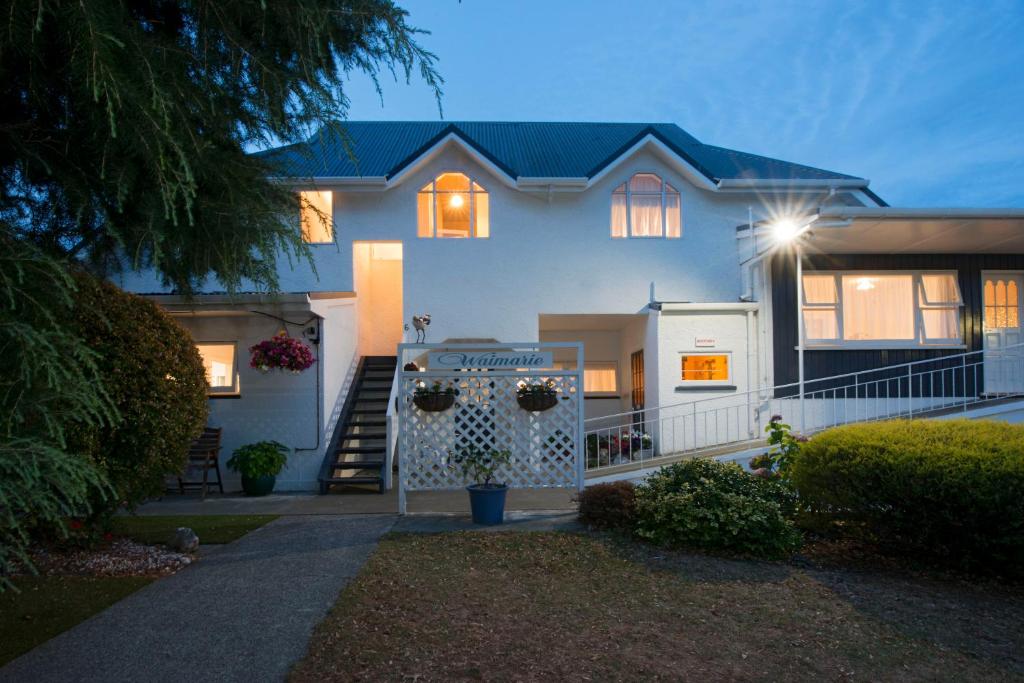 una casa blanca con una puerta delante de ella en Waimarie on Riverside Motel & Apartments, en Nelson