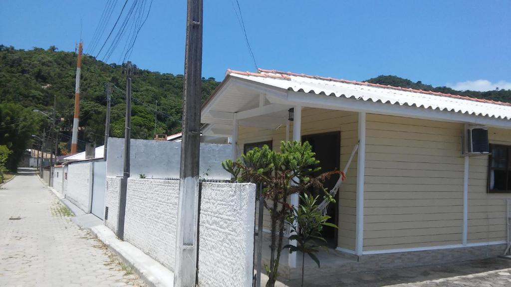 ein weißes Haus mit einem Zaun davor in der Unterkunft Linda casa in Florianópolis
