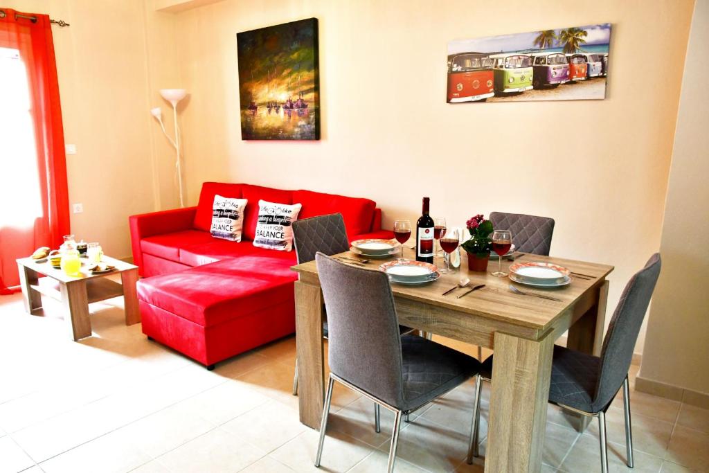 a living room with a table and a red couch at Luna Bianca - Corfu Apartments in Corfu Town