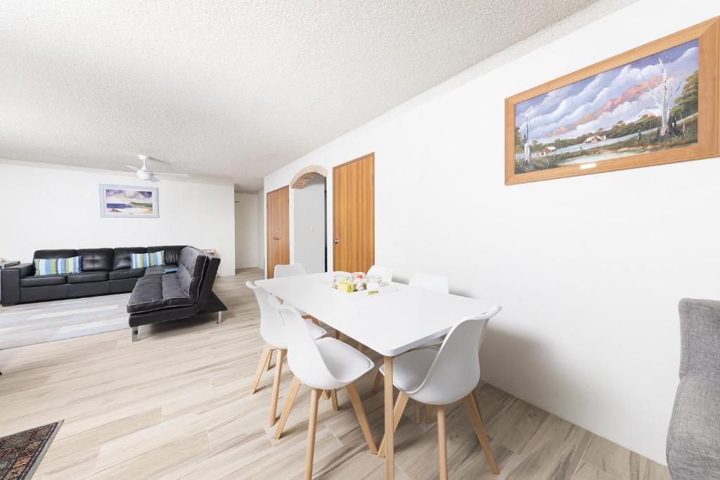 a living room with a white dining room table and chairs at Breakers 3 - linen not included in Forster