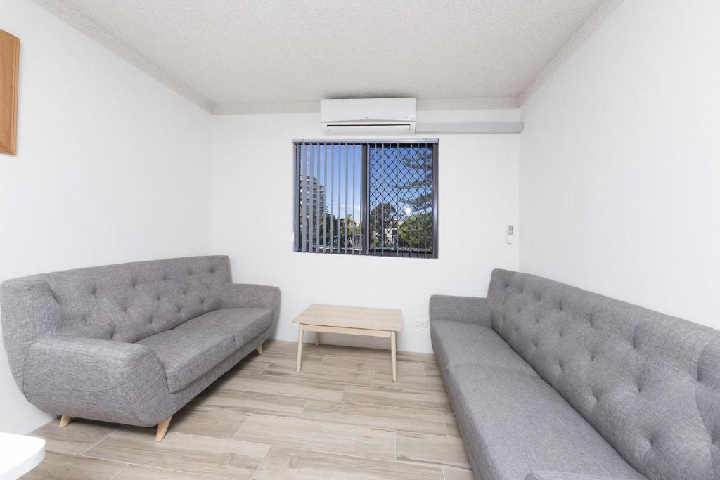 a living room with two couches and a table at Breakers 3 - linen not included in Forster