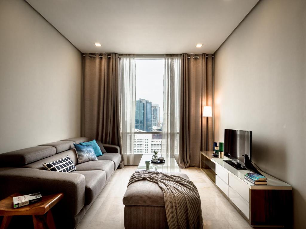 sala de estar con sofá y TV en Soho Suites KLCC by Airhost en Kuala Lumpur
