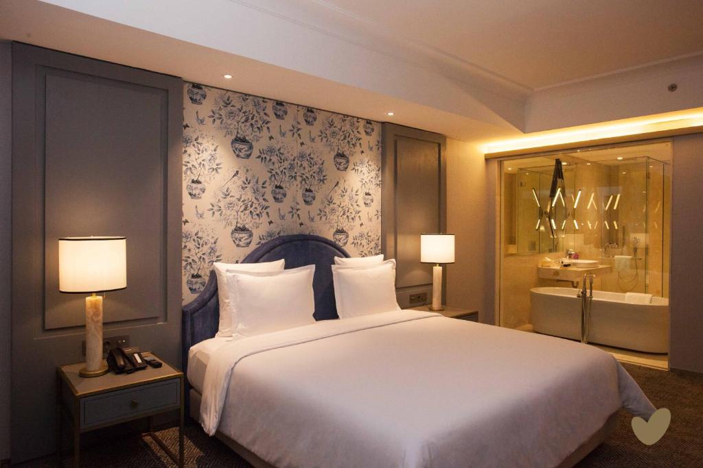 Postel nebo postele na pokoji v ubytování Goodrich Suites, Jakarta