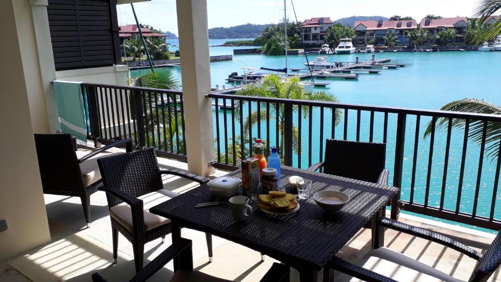 Eden Island luxury apartment sea view في جزيرة عدن: طاولة على شرفة مطلة على الماء