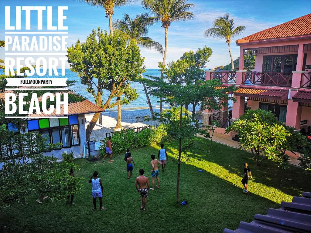 eine Gruppe von Menschen, die im Gras in der Nähe eines Resorts Fußball spielen in der Unterkunft Little Paradise Haad Rin Koh Phangan in Haad Rin