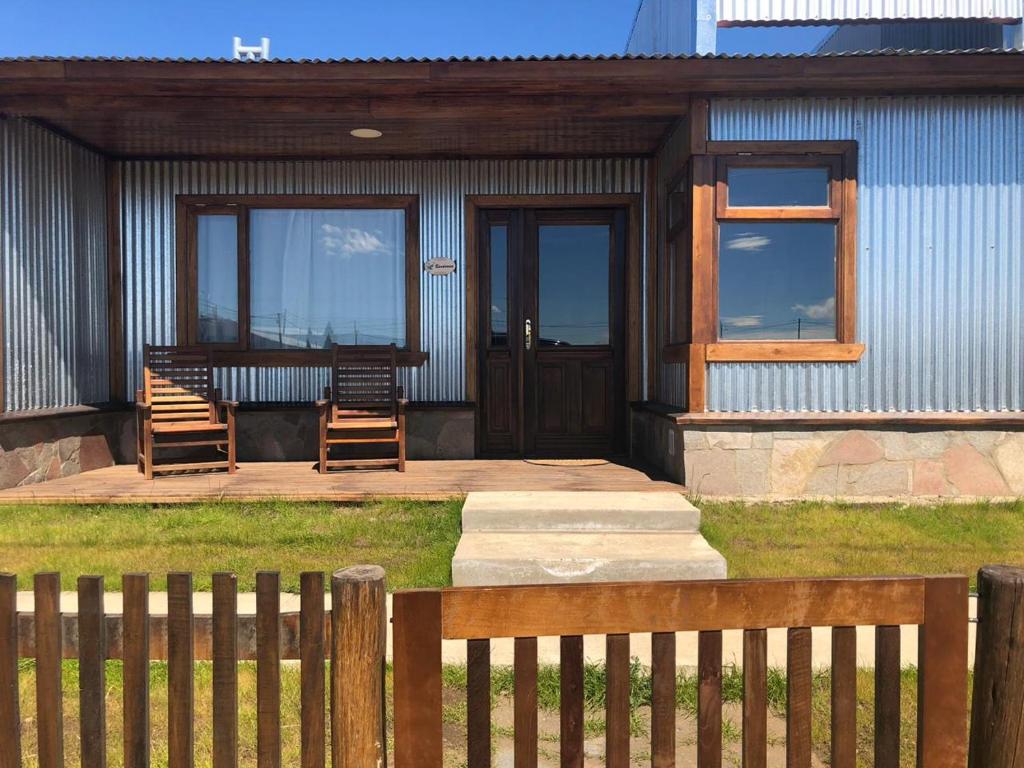 une terrasse couverte avec 2 chaises et une table sur une maison dans l'établissement Patagonia Austral Suites, à El Calafate