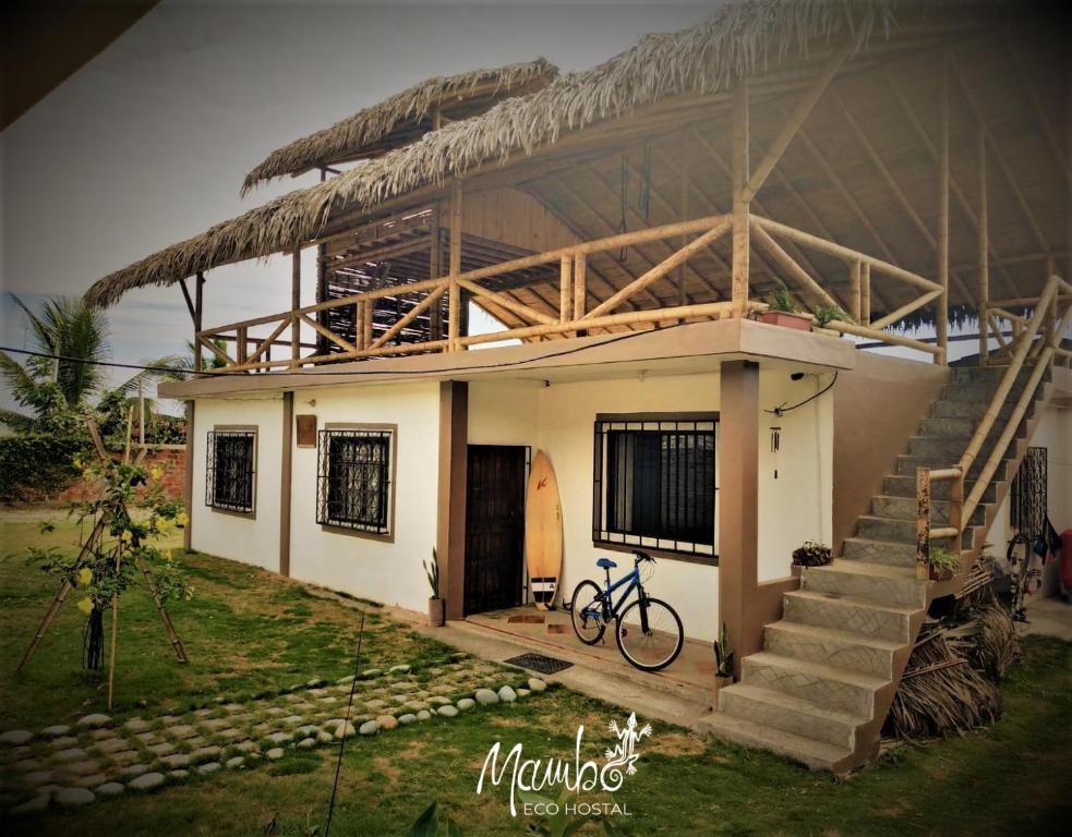 una pequeña casa con una bicicleta estacionada frente a ella en Mambo Ecohostal, en San Lorenzo