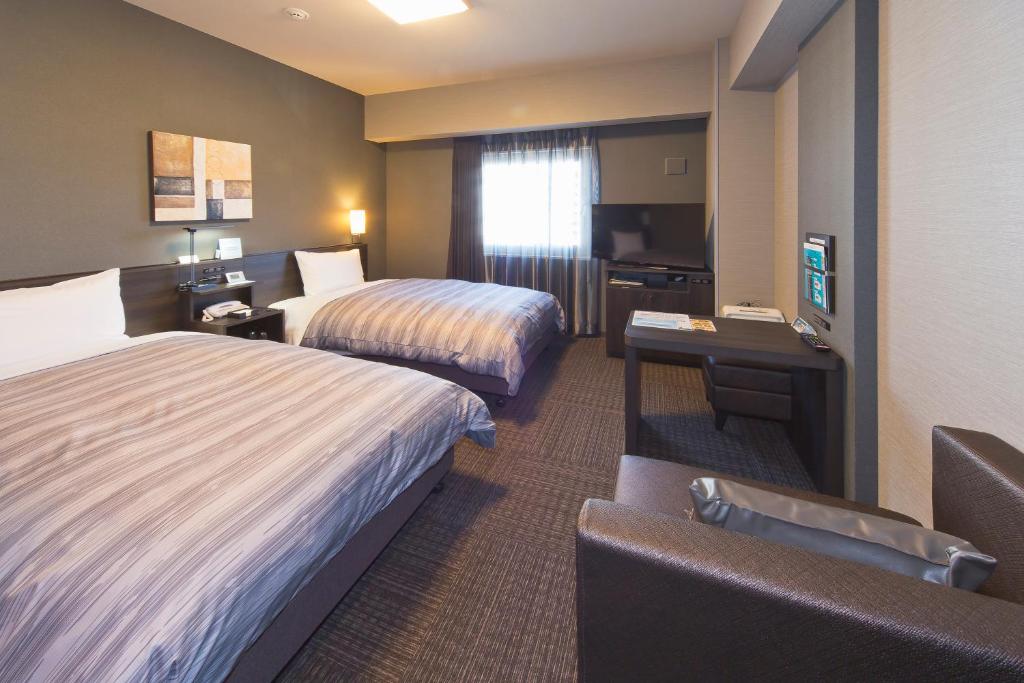 Postel nebo postele na pokoji v ubytování Hotel Route-inn Yamaguchi Yuda Onsen