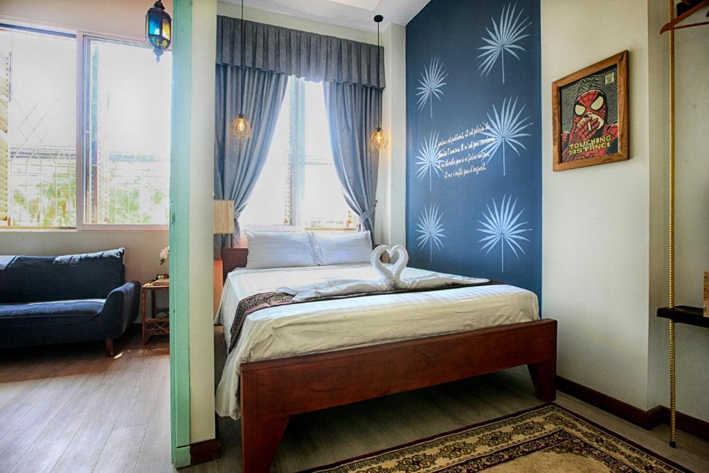 a bedroom with a bed and a blue wall at Candy Pepper in Kampot
