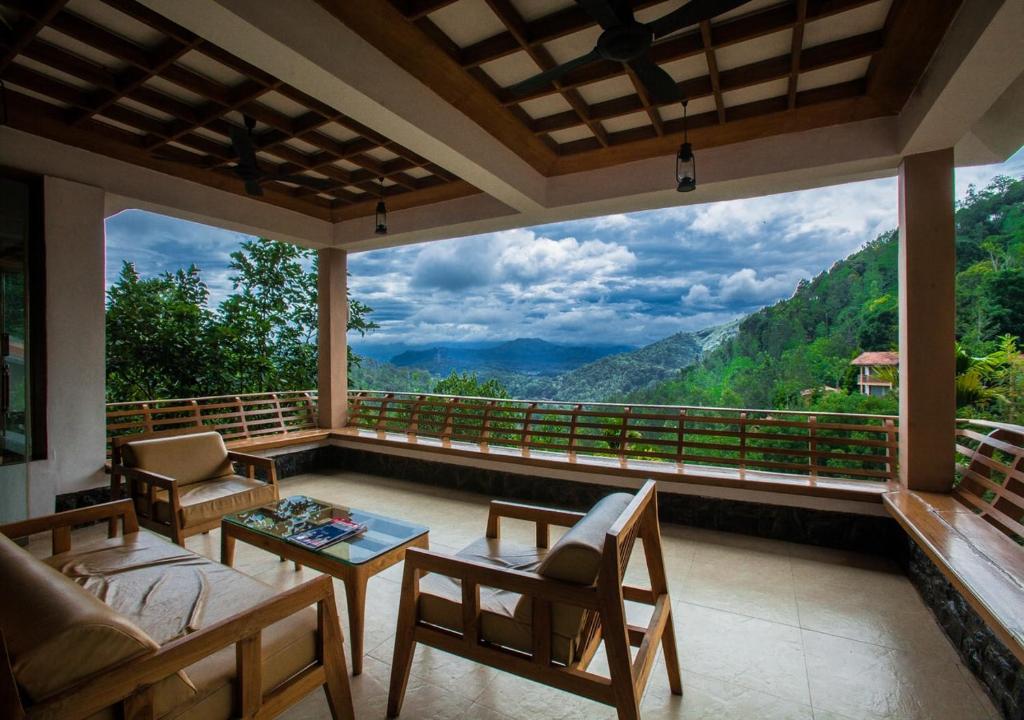 um quarto com uma varanda com vista em Oxygen Resorts Thekkady em Thekkady