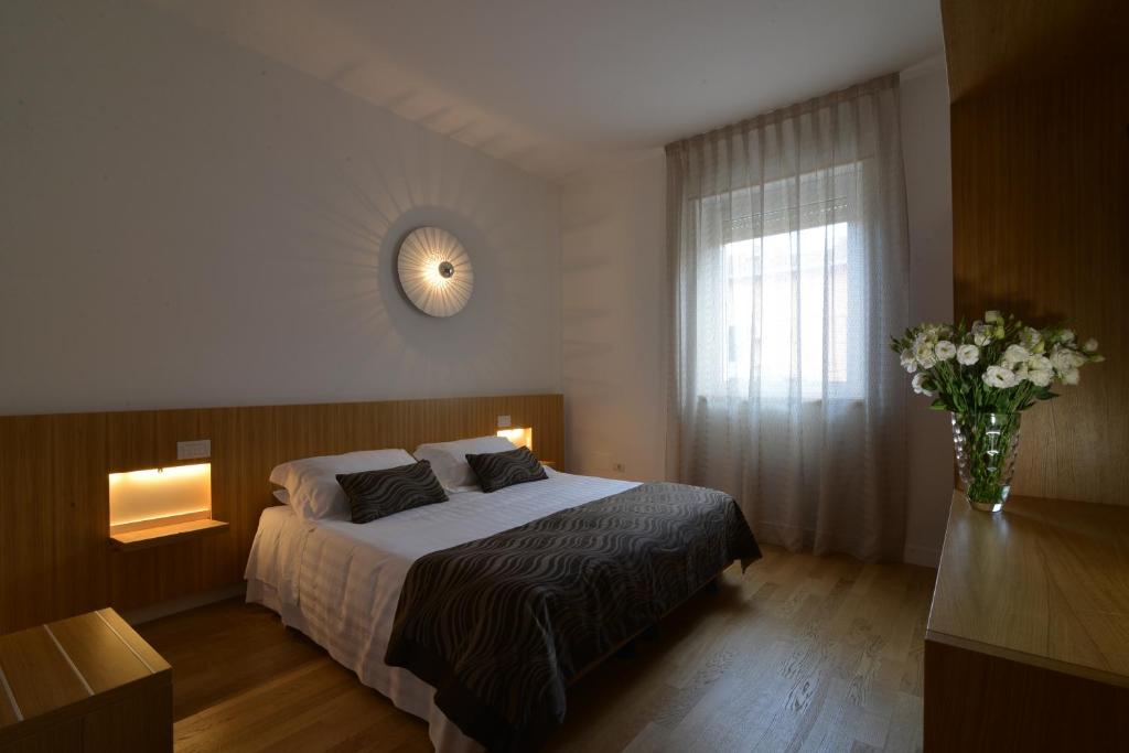 um quarto com uma cama e um vaso de flores em Hotel San Domenico Al Piano em Matera