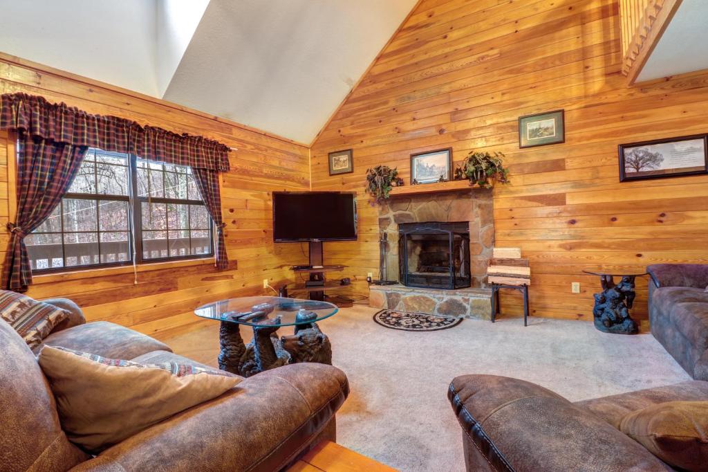a living room with a couch and a tv and a fireplace at Enchanted in Sevierville