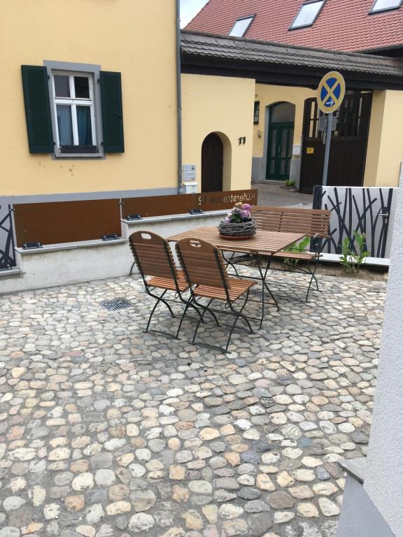 eine Terrasse mit einem Tisch und Stühlen auf einem Steinboden in der Unterkunft Schmuckkästle am Hafen in Wiesbaden