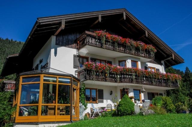 a house with a balcony with flowers on it at Haus Ornach in Oberjoch