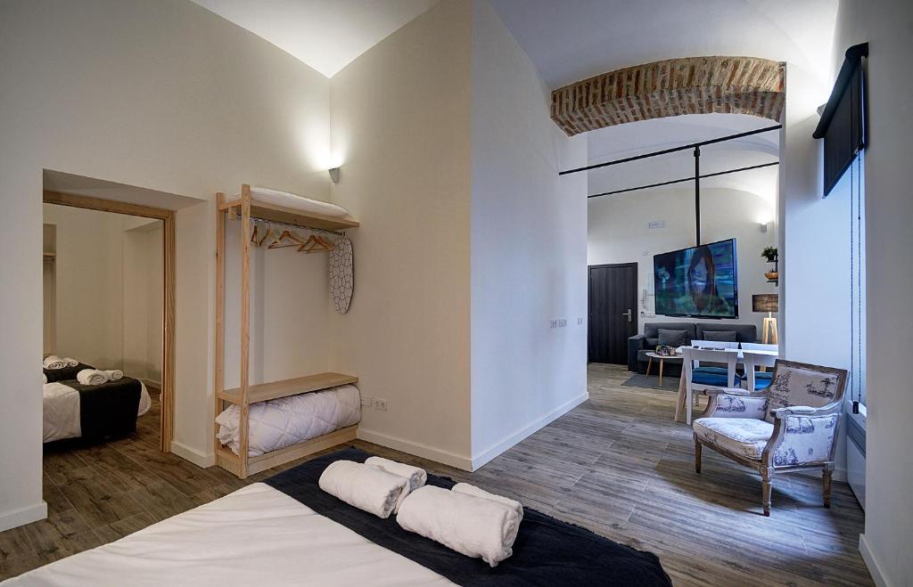 a room with a bed and a living room at Apartamentos AL-QAZERES LUXURY La Concepción in Cáceres