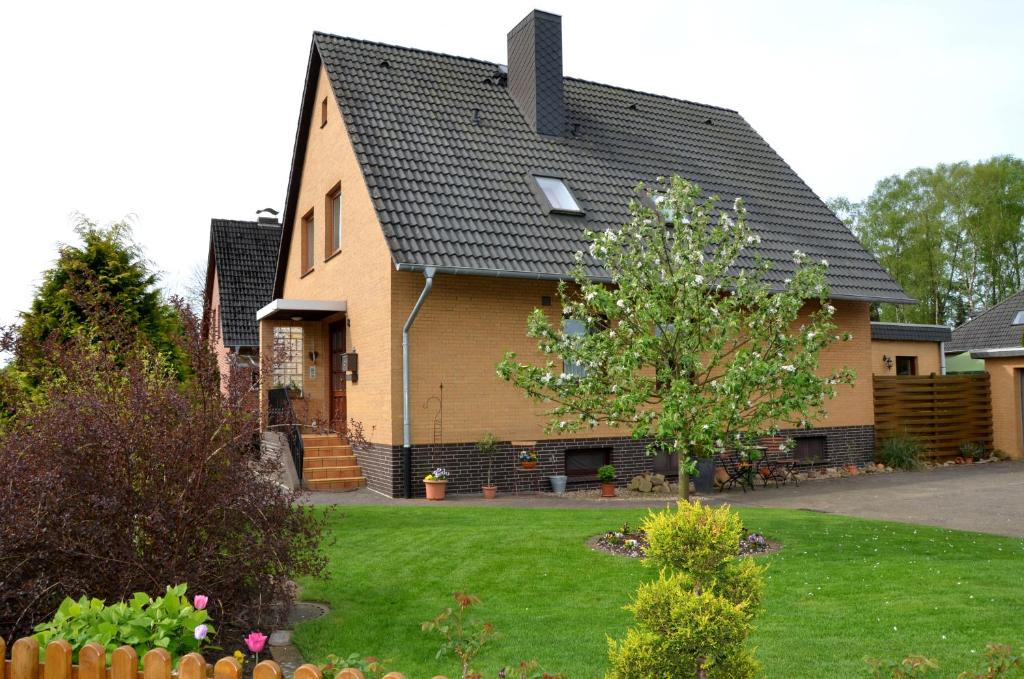 a house with a tree in the yard at Ferienwohnung Schultze in Munster im Heidekreis