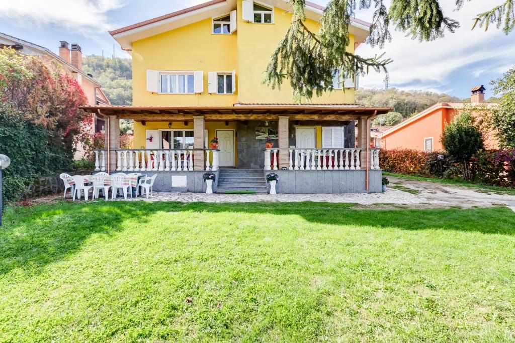 a yellow house with a porch and chairs at Le Tamerici in Rocca di Papa