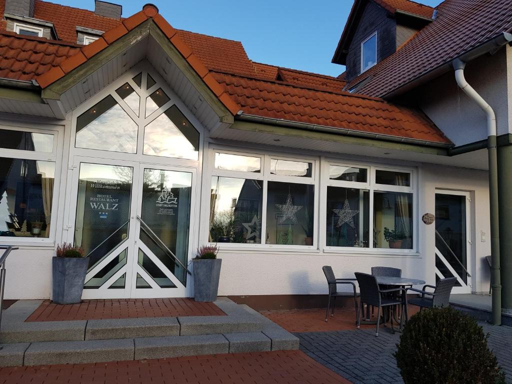 un edificio con ventanas, mesa y sillas en Hotel Walz, en Salzkotten