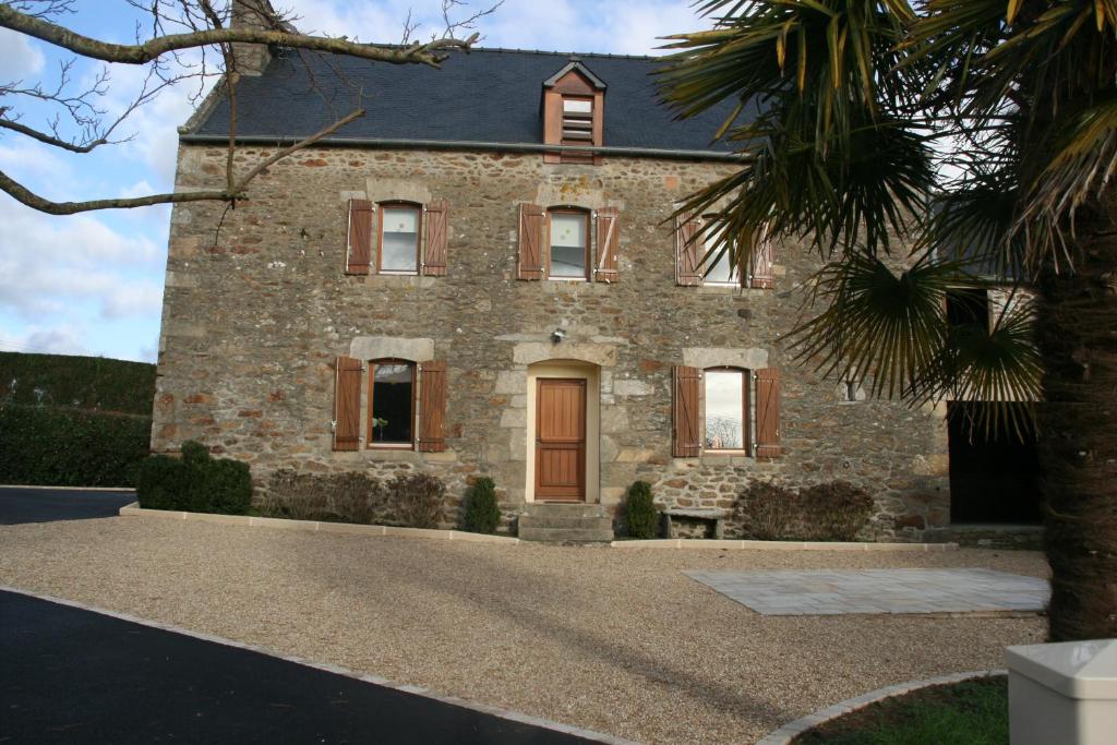 uma grande casa de pedra com uma porta de madeira em Gîte de Vacances - Côtes d Armor - Pluduno, Plancoët em Pluduno