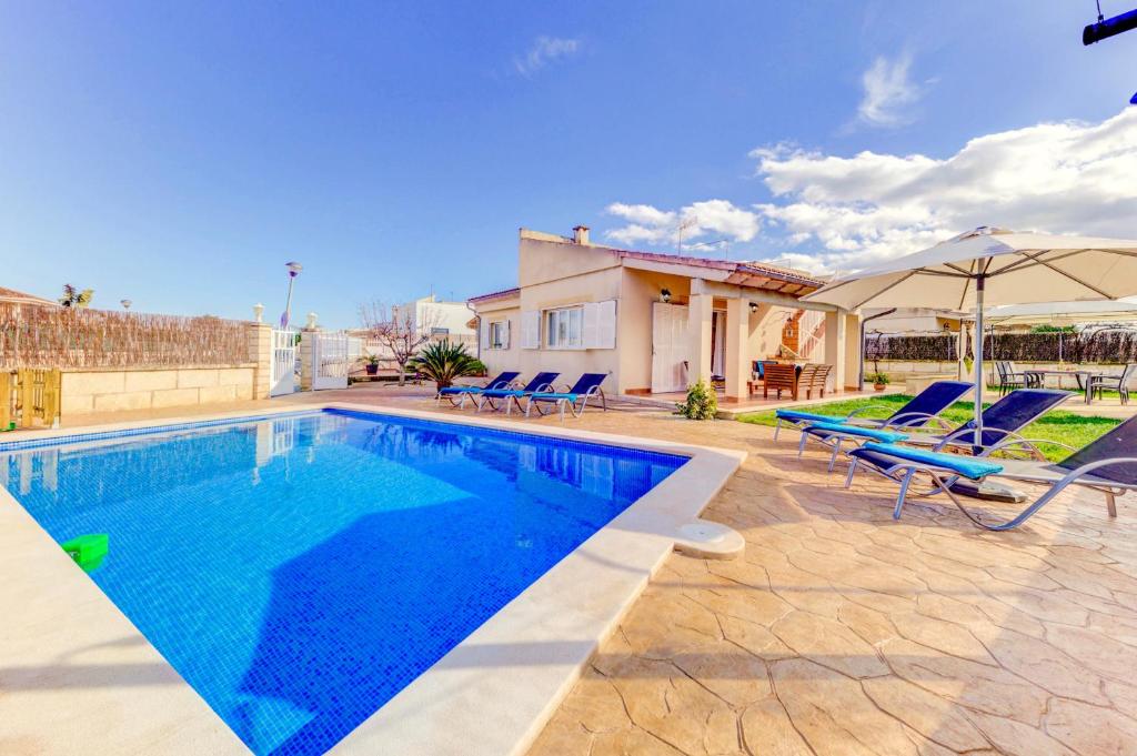 a swimming pool with blue chairs and a house at Can Gelaberts by Sealand Villas in Muro