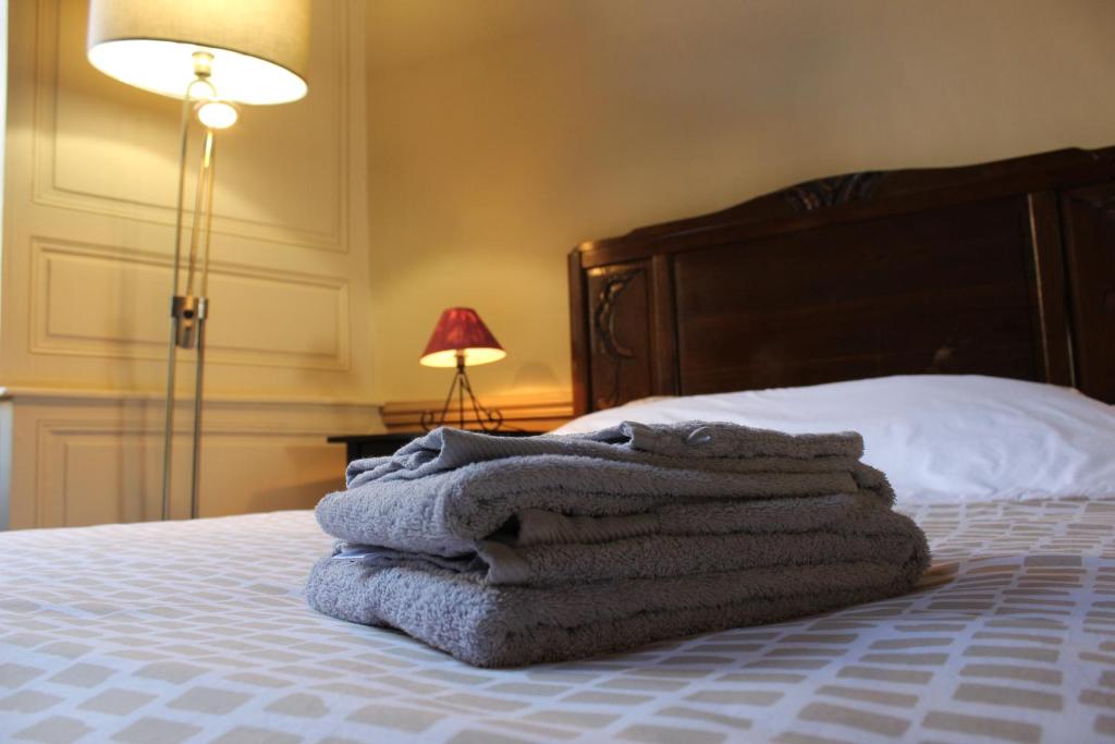 a pile of towels sitting on top of a bed at La Rapiette de Noblat in Saint-Léonard-de-Noblat
