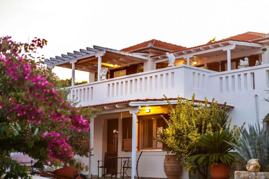 a white house with pink flowers in front of it at Anatoli Villa in Steni Vala Alonissos