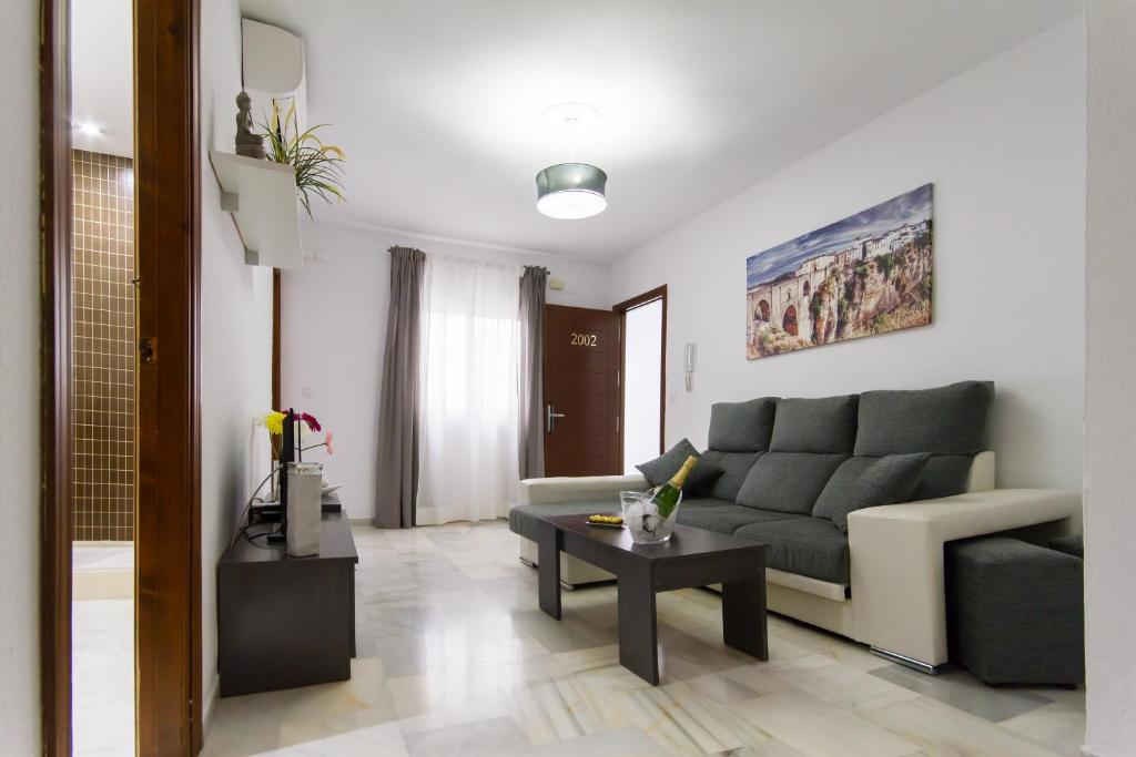 a living room with a couch and a table at Apartamentos El Tajo & SPA in Ronda