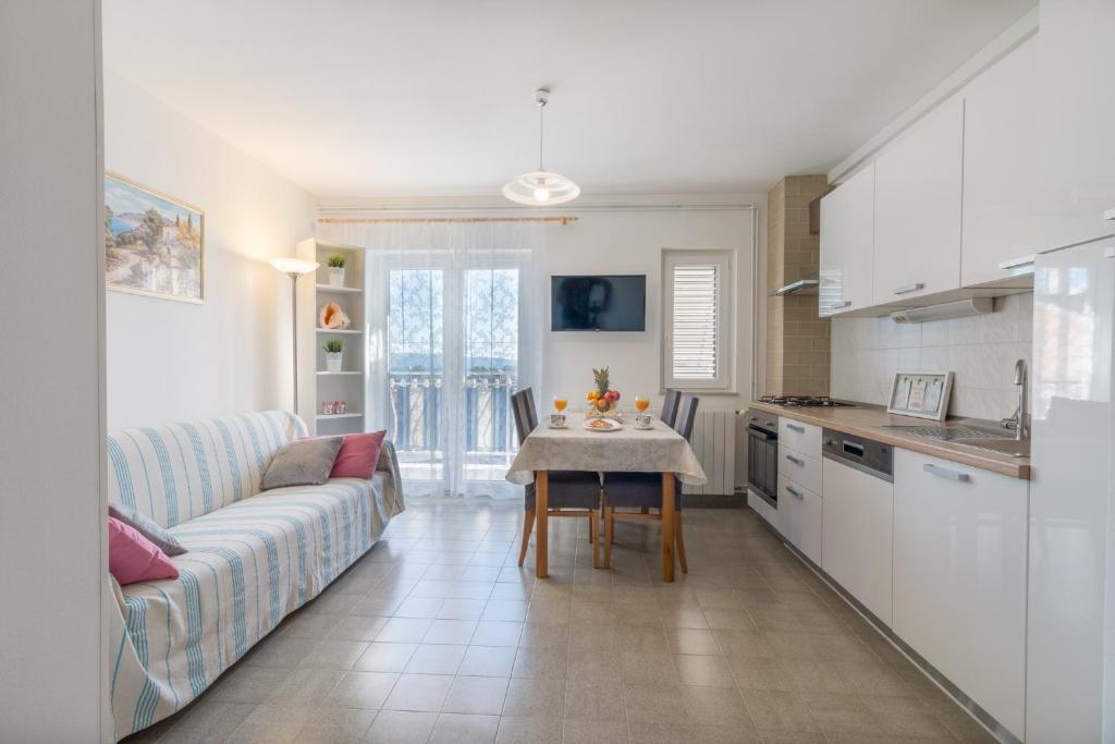 斯塔布魯克的住宿－Apartment La Mare，厨房以及带沙发和桌子的客厅。
