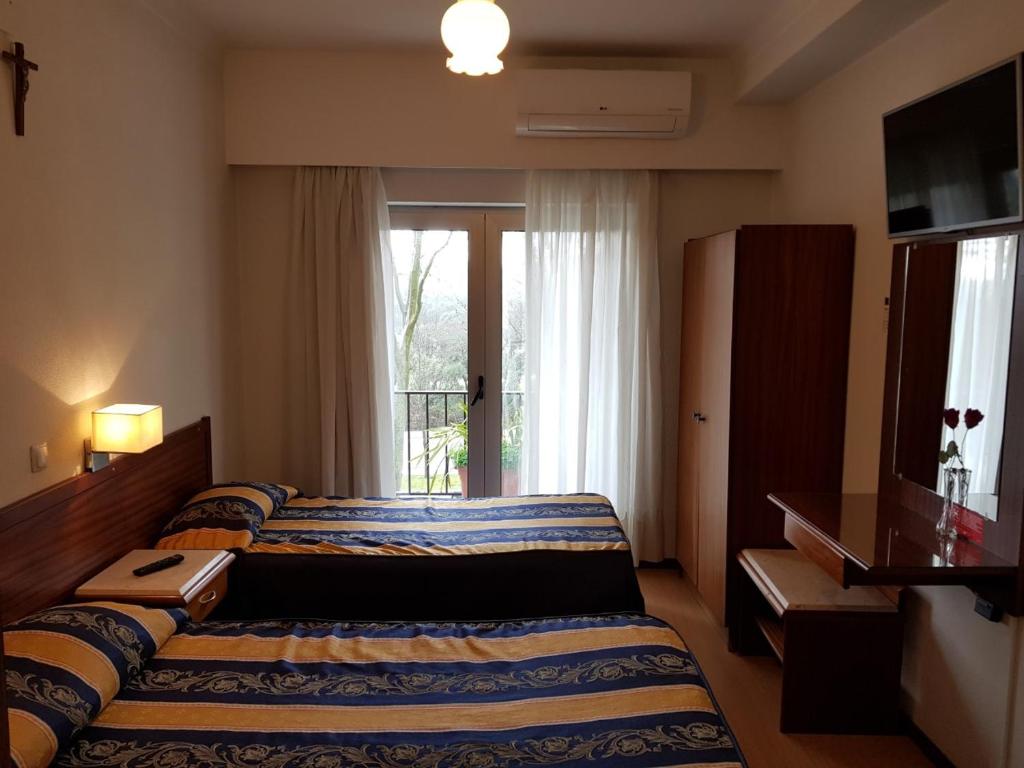 pokój hotelowy z łóżkiem i oknem w obiekcie Residencial Coroa D'Ouro w Fatimie