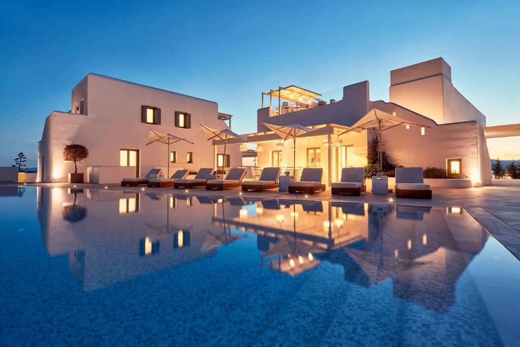 a villa with a swimming pool at night at 18 Grapes Hotel in Agios Prokopios