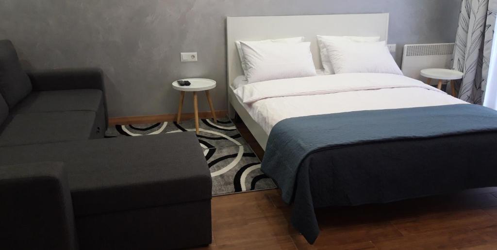 a small bedroom with a bed and a couch at Однокомнатная квартира-студия. Новострой, центр города. in Lutsk