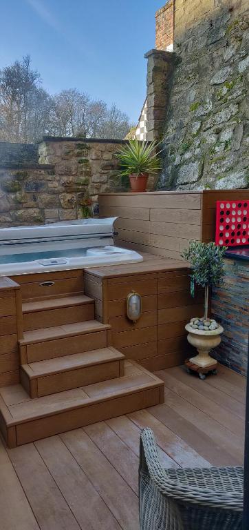 un patio con bañera de hidromasaje y escaleras en Teardrop Cottage en Knaresborough