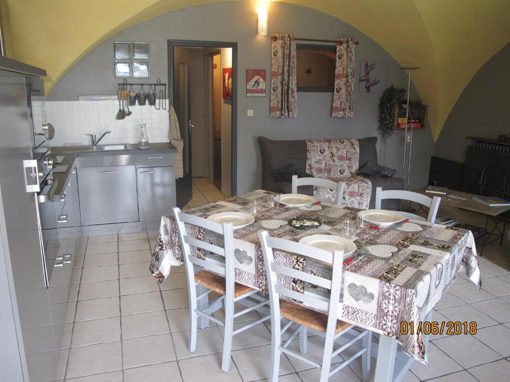 een eettafel met stoelen en een keuken bij La Rose des Vents in Saint-Bonnet-en-Champsaur