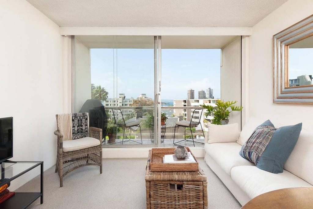 a living room with a white couch and a large window at Home with a View with Pool and Roof Terrace Garden in Sydney