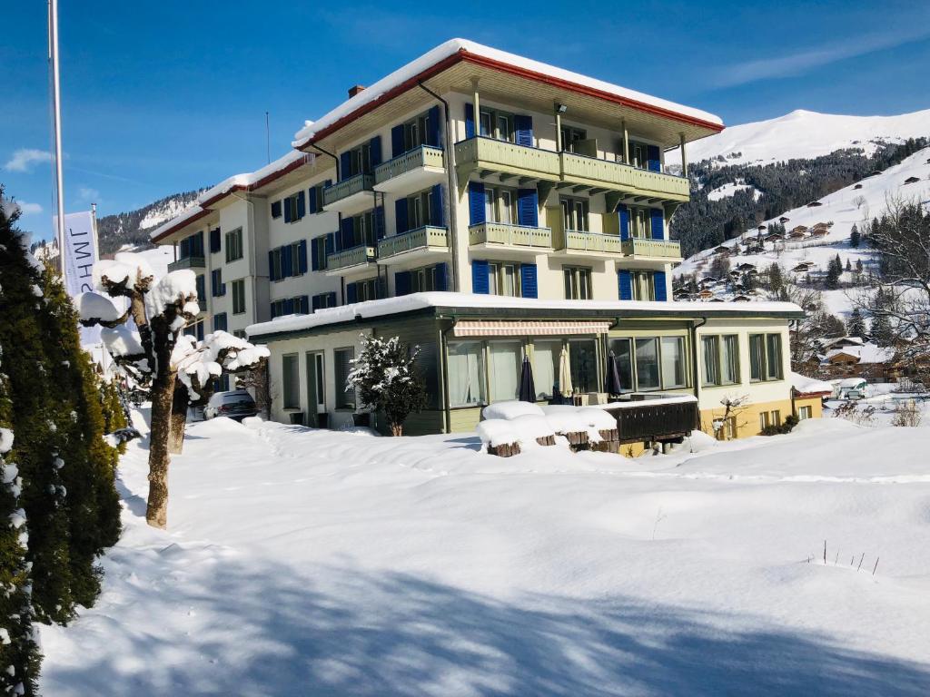 a large building in the snow with snow at Parkhotel Bellevue in Lenk