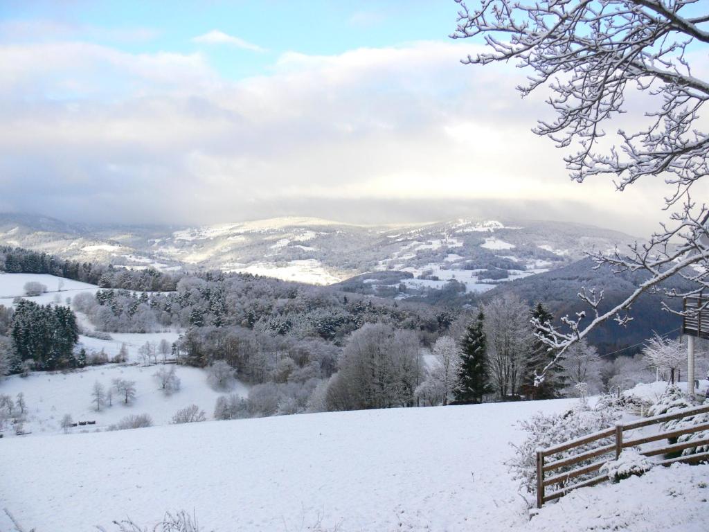 a snow covered hill with mountains in the distance at Gîte la Sapinière in Labaroche